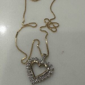 This is a yellow gold open heart diamond pendant necklace on a gold chain